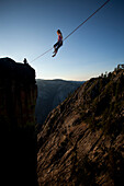 Female highliners sitting on the highline and anchor above the Yosemite Valley floor at Taft Point