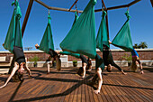 A group performs aerial yoga in San Diego California.