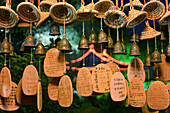 Lucky charms in form of small bells, wicker hats and wooden plates with Chinese hand writing at Shenyuan in Shaoxing.