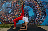 Female stretching in front of wall covered in graffiti near Boulder, Colorado