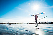 Man in winter going Stand Up Paddleboarding in Kittery Maine