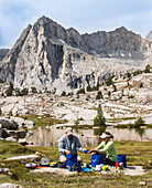 Couple washing dishes near high Sierra lake