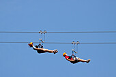 Two women ride a zip line in Whitefish, Montana.