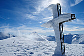 Frozen cross on the mountain top.