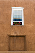 'Flowers in a window in the back of a historic church; Velarde, New Mexico, United States of America'