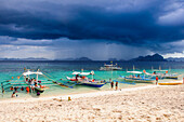 Outrigger boats before a strom anchoring on a sandy beach  in  the Bacuit archipelago, Palawan, Philippines, Southeast Asia, Asia