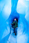 Woman standing in an ice cave, Fox Glacier, Westland Tai Poutini National Park, South Island, New Zealand, Pacific