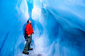 Man standing in an ice cave, Fox Glacier, Westland Tai Poutini National Park, South Island, New Zealand, Pacific