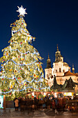 Old Town Square Christmas Market with Christmas Tree, Jan Hus Monument and Baroque Church of St. Nicholas at twilight, Old Town, UNESCO World Heritage Site, Prague, Czech Republic, Europe