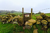 Footpath gate and dry stone wall near Elton on a murky spring day, Peak District National Park, Derbyshire, England, United Kingdom, Europe
