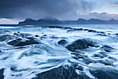 Waves crash against the black basalt rocky shores of Gjogv, Eysturoy, Faroe Islands, Europe