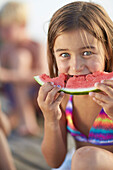 Girl eating a slice of melon, lake Starnberg, Upper Bavaria, Bavaria, Germany