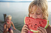 Girl eating a slice of melon, lake Starnberg, Upper Bavaria, Bavaria, Germany