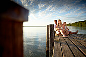 Familie auf einem Steg am Starnberger See, Oberbayern, Bayern, Deutschland