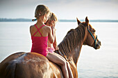 Two girls on horse back at lake Starnberg, Upper Bavaria, Bavaria, Germany