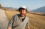 Young man laughing at camera, Grosser Alpsee, Immenstadt, Bavaria, Germany