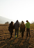 Gruppe junger Leute geht über eine Wiese, Großer Alpsee, Immenstadt im Allgäu, Bayern, Deutschland