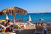 Group of people on the beach.Tropicana Bar. Jondal Beach. Sant Josep de sa Talaia. Ibiza. Balearic Islands. Spain.