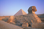 EGYPT.CAIRO.GIZEH.THE SPHINX AND PYRAMIDS AT BACK AT SUNRISE.