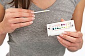 woman holding a urine analysis self test to test glucose for diabetes