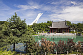 The Friendship Hall pavilion and the Dream Lake in summer at the Chinese Garden. The Olympic Stadium Tower is visible in the background. Montreal Botanical Garden, Montreal, Quebec, Canada, Not released Editorial use only.