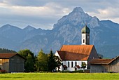 Church tower rises towards Alps, Speiden, Bavaria, Germany
