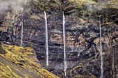 Waterfalls streaming out of the rocks, Mt. Lomagnupur, Eastern, Iceland.