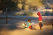 Herero Kinder mit Hahn an einer Feuerstelle, Sesfontain, Namibia