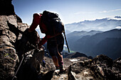 Frau klettert durch Felsen, Abstieg vom Habicht (3277 m), Stubaier Alpen, Tirol, Österreich