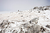 Hiker walking in snow-covered landscape, ascend to Unnutz Mountain (2078 m), Rofan Mountains, Tyrol, Austria