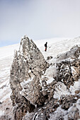 Hiker standing in snow-covered landscape, ascend to Unnutz Mountain (2078 m), Rofan Mountains, Tyrol, Austria