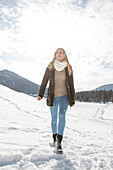 Young woman walking in snow, Spitzingsee, Upper Bavaria, Germany