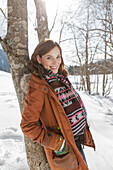 Young woman leaning against a tree, Spitzingsee, Upper Bavaria, Germany