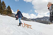 Two young women with a sled, Spitzingsee, Upper Bavaria, Germany