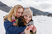 Two young women embracing, Spitzingsee, Upper Bavaria, Germany