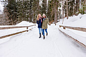 Zwei junge Frauen spazieren im Schnee, Spitzingsee, Oberbayern, Bayern, Deutschland