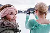 Young women taking a smart phone picture, Spitzingsee, Upper Bavaria, Germany