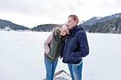 Two young women on a jetty enjoying view, Spitzingsee, Upper Bavaria, Germany