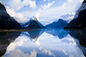 New Zealand, Southland, Fiordland National Park  A clearing storm above Mitre peak, reflected in the still waters of the Milford Sound
