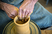 clay being shaped on a rotating pottery wheel by the potter in the pottery, Vellberg, Schwaebisch Hall, Baden-Wuerttemberg, Germany