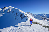 Frau auf Skitour steht im Col Sautron, im Hintergrund Monte Viraysse und Tete Peymian, Col Sautron, Valle Maira, Cottische Alpen, Piemont, Italien