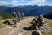 Three mountain bikers between Cairns at Latemar, Trentino Italy