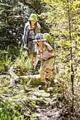 Zwei Mädchen wandern vom Binnenland zur Küste des Abel Tasman Nationalparks, Südinsel, Neuseeland