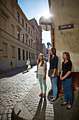 Three girlfriends Annija, Luize and Eliza singing for tourists, street choir on the corner of Jekaba and Maza Pils Iela, old town centre, Riga, Latvia