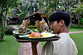 Waiter with fish dish, Restaurant Mekong near My Tho in the delta of Mekong river, Vietnam, Asia