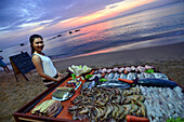 Woman selling fish, sunset at Longbeach on the island of Phu Quoc, Vietnam, Asia
