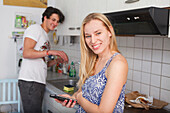 Young couple in the kitchen, woman on her mobile
