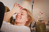 Young woman relaxing on the sofa, Laughing