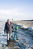 Young mother walking with her son on the beach, Cuxhaven, North Sea, Lower Saxony; Germany