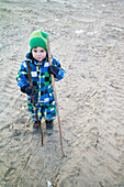 Boy with sticks on the beach, Cuxhaven, North Sea, Lower Saxony, Germany